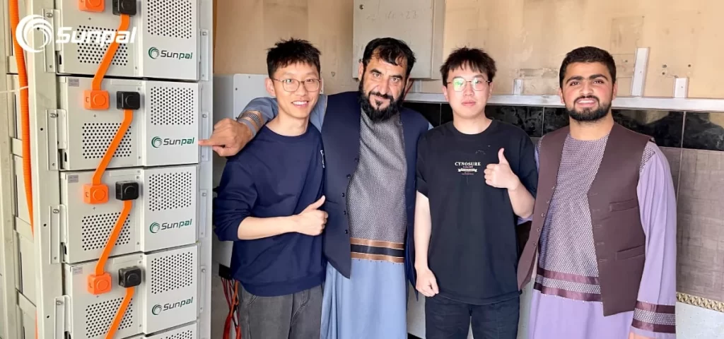 Photo de groupe des employés de Sunpal et d'un client afghan sur un site d'installation.