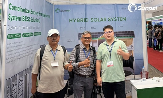 Three men posing with thumbs up at Sunpal Energy booth showcasing hybrid solar system.