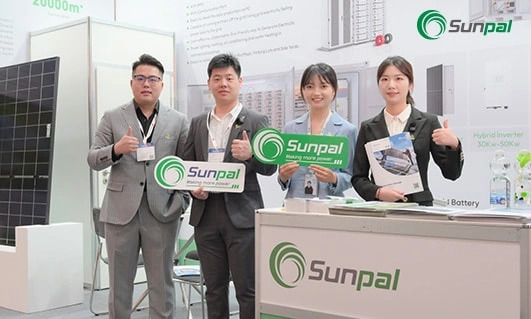 Four Sunpal Energy representatives standing by their booth, holding promotional materials.